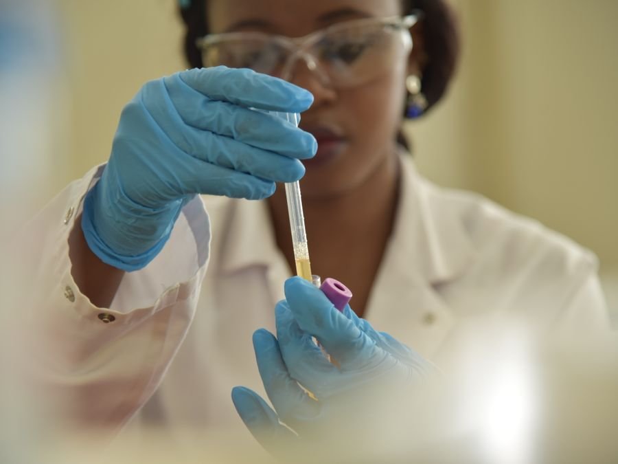 Lab scientist handling a sample with gloved hands